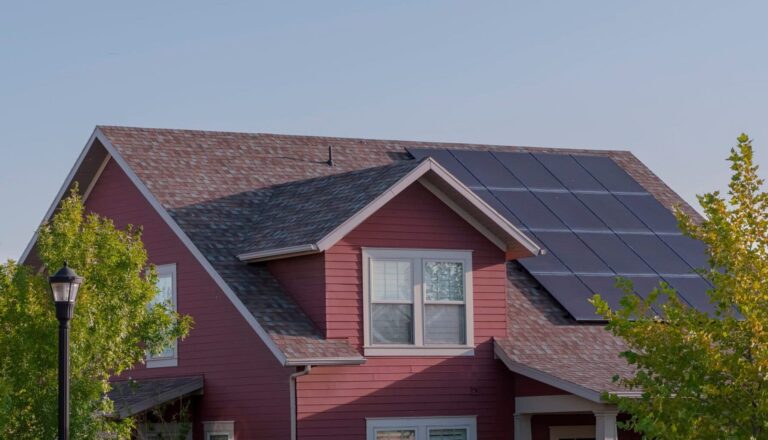 Array of photovoltaic solar panels for renewable green energy on a roof of a suburban house
